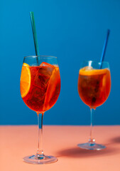 a couple of glasses filled with Aperol Spritz cocktails drinks on top of a table