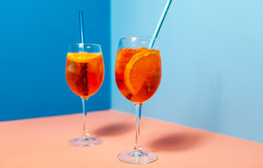 a couple of glasses filled with Aperol Spritz cocktails drinks on top of a table