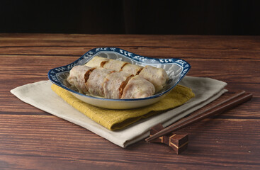 Homemade traditional asian food nyonya Popiah Spring Roll fresh vegetables, bean curd, fried shallots, dried shrimp, sweet chili paste and braised turnip on wood table vegan halal menu for cafe