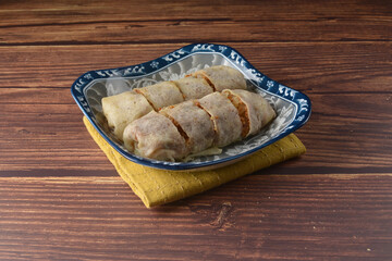 Homemade traditional asian food nyonya Popiah Spring Roll fresh vegetables, bean curd, fried shallots, dried shrimp, sweet chili paste and braised turnip on wood table vegan halal menu for cafe