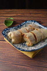 Homemade traditional asian food nyonya Popiah Spring Roll fresh vegetables, bean curd, fried shallots, dried shrimp, sweet chili paste and braised turnip on wood table vegan halal menu for cafe