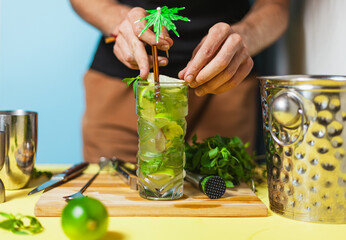 a man is preparing Mojito Cocktail drink on a table
with professional bartender utensils