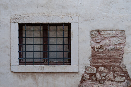 old window on the facade of an old wall - Powered by Adobe