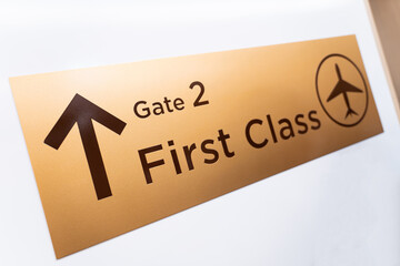 The gate 2 sign at the airport shows a designated lane for first class passengers
