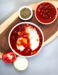 Traditional South African Pap and sauce, tomato and onion relish, flat lay with wooden board and...