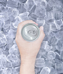Hand holding cold drink can with ice, top view.