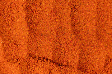 Ground paprika, red terracotta spice background, art in cooking.