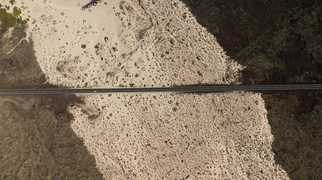 Aerial view of beautiful patterns of sand and road in a natural landscape, Caleta del Mojon, Lanzarote, Spain.