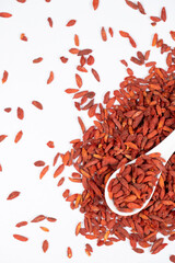 Dried Goji berries Lycium barbarum in a spoon on a white background