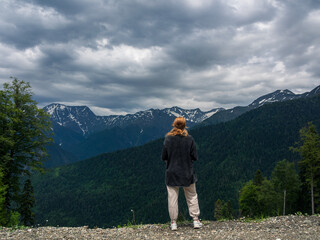A man with outstretched arms against the background of majestic mountains, personifying freedom,...