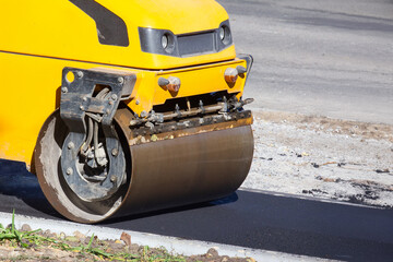 asphalt roller at work repairing a road for pedestrians