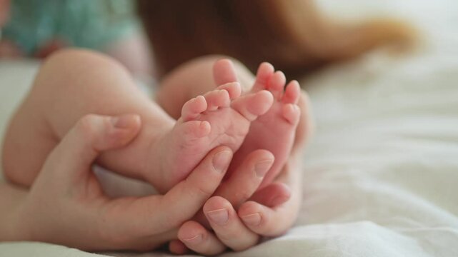 Happy family. Tiny newborn infant male or female baby feet on mother hands. Mother holding newborn child. Mom and her baby. Maternity tenderness parenthood new life concept. Handle with care