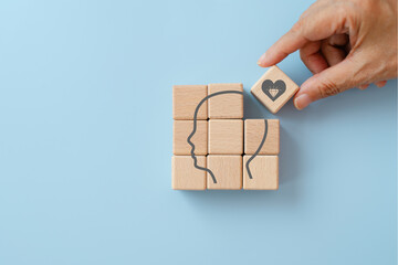 For core values, corporate values concept, hand arranged wooden cube blocks  with head and core value symbol  on blue background