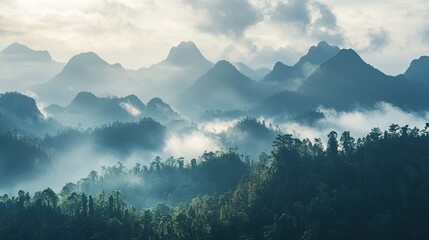 Majestic Southeast Asian mountain range with mist-covered peaks, serene landscape, no people