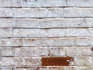 Whitewashed brick wall with peeling paint and rustic texture in an urban setting