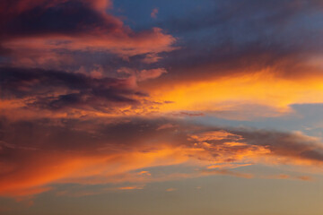 the sky transforms into a dramatic canvas of purples and fiery reds, casting a warm glow across the horizon as the sun dips below, leaving a stunning afterglow