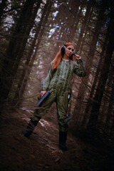 Girl an astranaut concept walking through the dark forest on another planet concept. Space traveler.