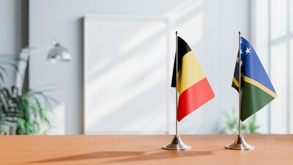 FLAGS OF BELGIUM AND SOLOMON ISLANDS ON TABLE