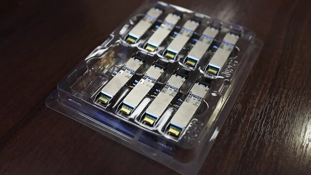 Optical transceiver modules in a blister pack on a table. 