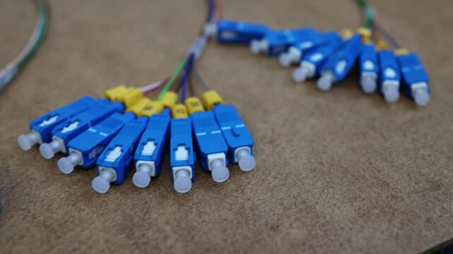 Colorful fiber optic cables arranged on a workbench surface