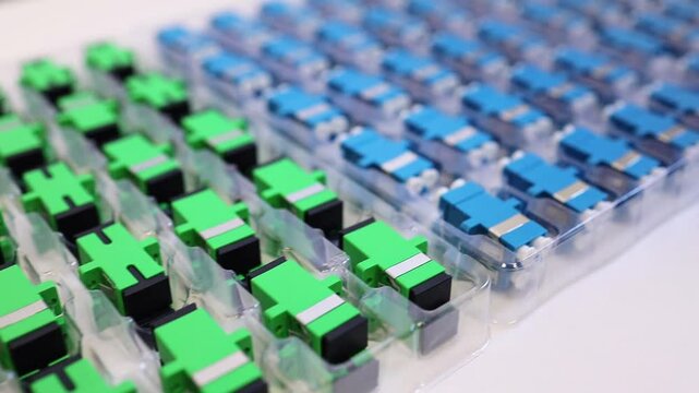 Optical adapters with different connectors in plastic blisters on the table, a batch of goods