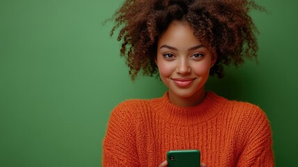 A young woman in casual attire, smiling, using her smartphone with an engaging expression against a green screen.