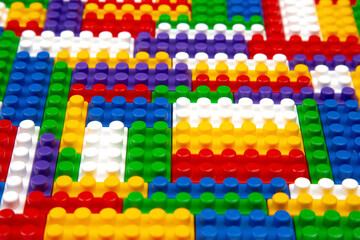 Abstract background texture of colored constructor blocks. Background of colorful plastic part of constructor. Pile of colored toy bricks.