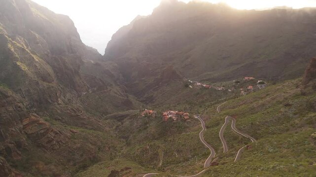Aerial view of the picturesque valley with a winding road and a remote village surrounded by majestic mountains, Masca, Spain.