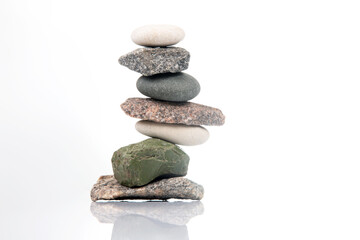 pyramid of stacked stones on a white background. stabilization and balance in life