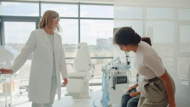 Boy entering cabinet with mom and shaking hands with doctor
