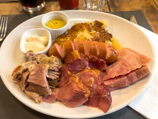 Traditional Austrian meat platter of different types of meat, potatoes, mustard and butter