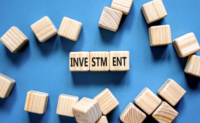 Investment symbol. Concept word Investment on beautiful wooden blocks. Beautiful blue background....