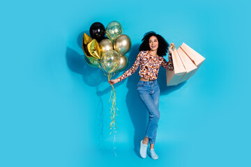 Photo of attractive cute glad woman wear stylish clothes hold balloon store mall sale empty space isolated on blue color background