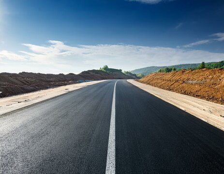 Route droite en asphalte en construction et inachev&eacute;e avec un ciel bleu dans la campagne