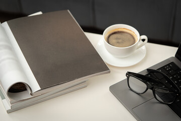 Modern Workspace With Laptop, Glasses, and Magazines