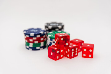 Red dice with stacked poker chips on a white background