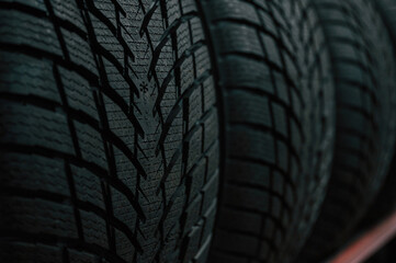 Particle close up view. New tires are placed on the storage rack in the car workshop