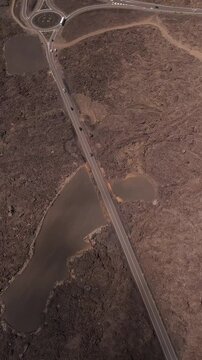 Aerial view of volcanic terrain with a winding road and roundabout, Parque Nacional de Timanfaya, Yaiza, Spain.