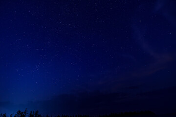 Star-filled night sky with a meteor streak and clouds