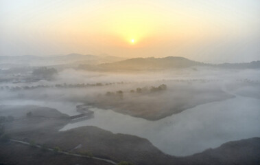 Aerial and autumnal view of fog on deck trail and wetland at Sorae Wetland Park in the morning near Incheon, South Korea 