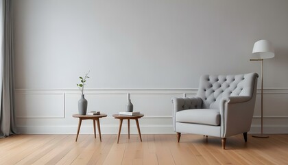 A gray tufted armchair in a minimalist living room with white walls and wooden floors.