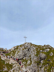 Fototapeta premium Tourists are enjoying a challenging climb on a rocky mountain path to reach the summit of giewont mountain in poland