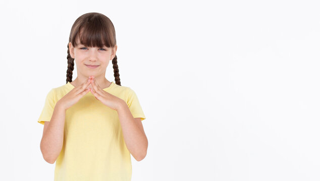 I have great evil plan. Confident and tricky girl in yellow t-shirt, holding fingers together and smirking at camera, having some bad intention in mind, planning to commit crime