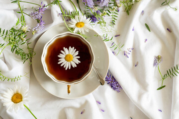 Herbal tea, chamomile flowers and honey on rattan matting Close-up