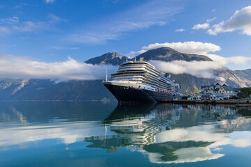 Cruise ship docked in the town of Eidfjord with low hanging clouds, Norway