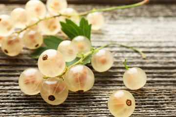 Fresh white currant berries and green leaf on wooden table, closeup