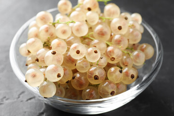 Fresh white currant berries in bowl on gray textured table, closeup