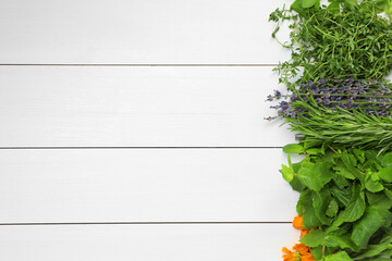 Different aromatic herbs on white wooden table, top view. Space for text