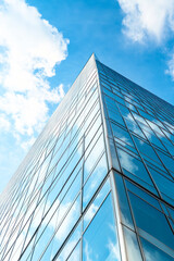 Modern skyscraper reflecting the blue sky and clouds.