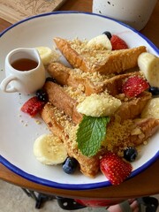 French toast served with fresh fruits and syrup, beautifully plated